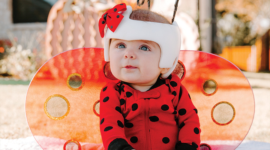 Baby girl dressed as a lady bug wearing a doc band