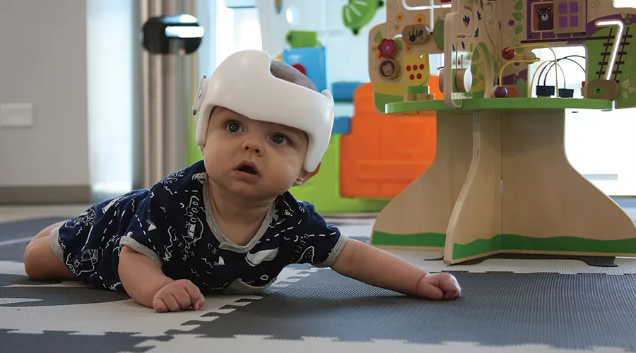 Baby crawling on floor in a cranial technologies clinic