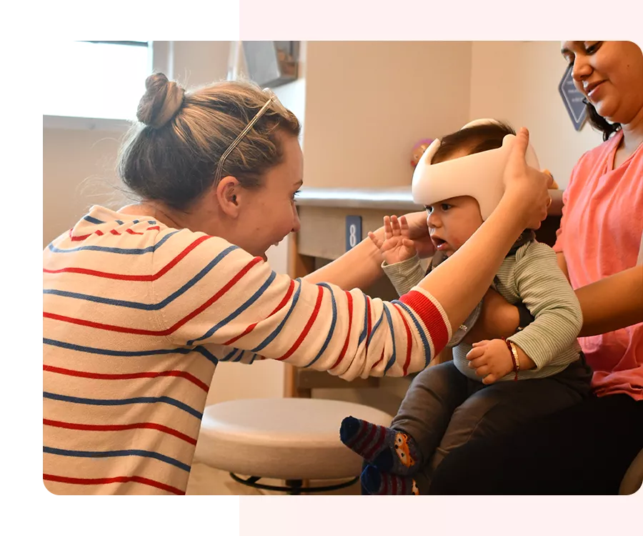 Clinician adjusting a baby's DOC Band during a growth appointment.